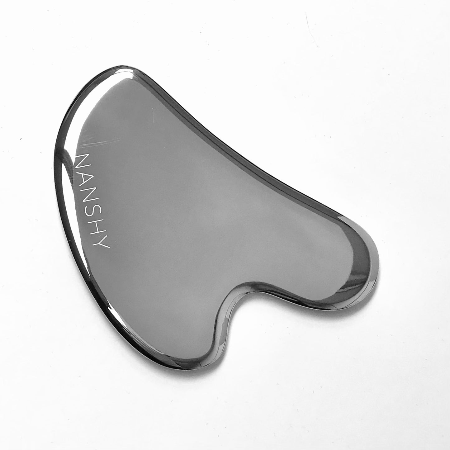 Stainless steel Gua Sha tool with smooth edges, engraved with the brand name "Nanshy."