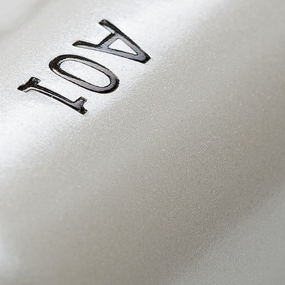 Close-up of the "Flat Definer" makeup brush handle with a pearl-coated finish and the number "AO1" printed on it.